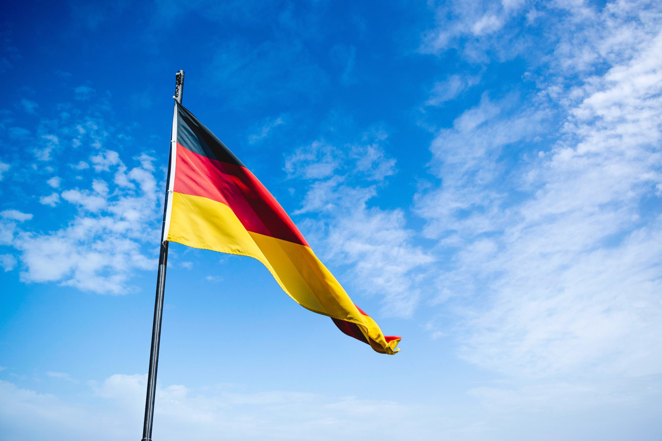 German flag waving in wind with blue background