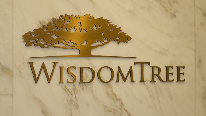 WisdomTree Investments gold company logo inside of a building on a marble wall