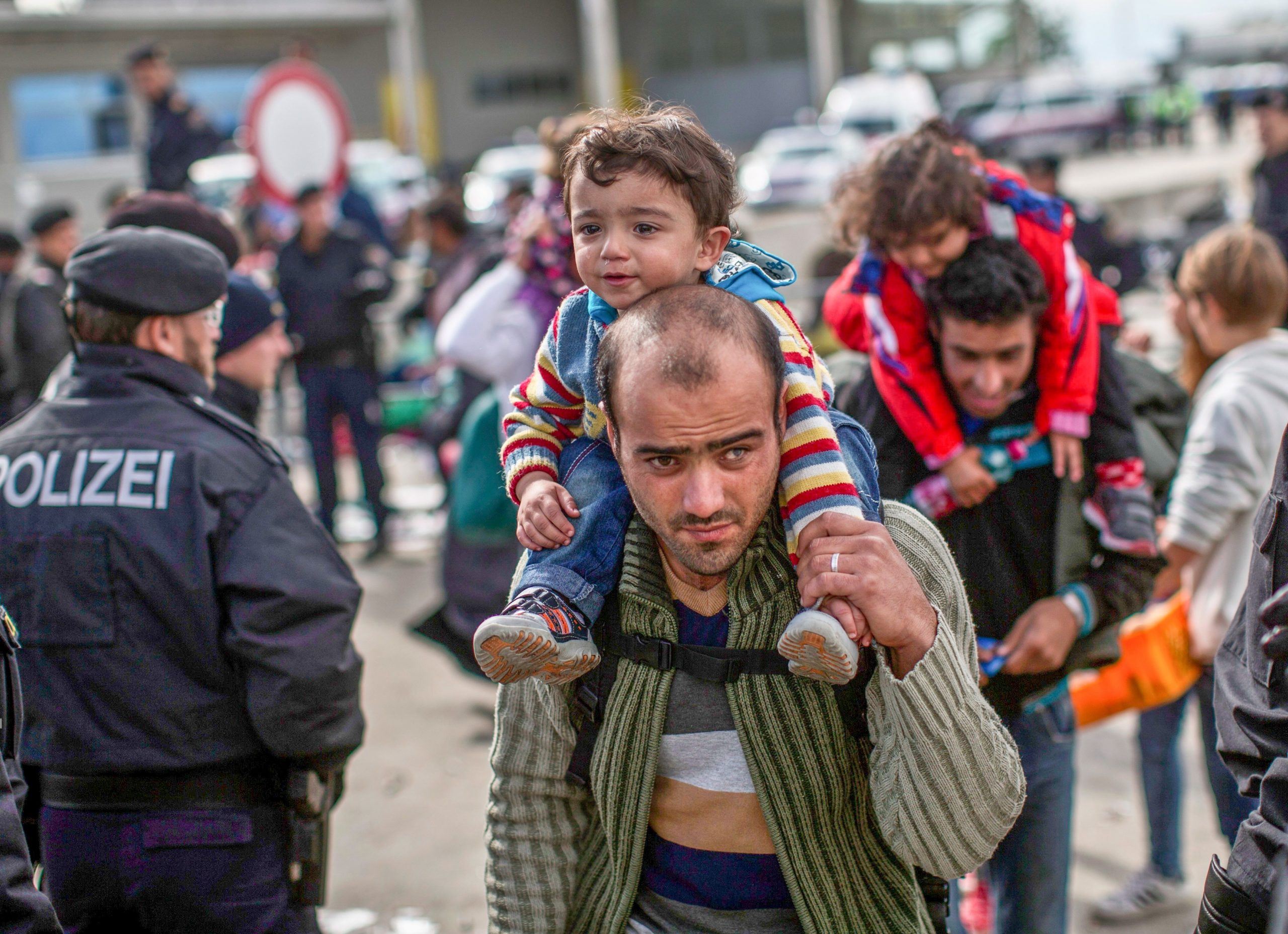 European refugee father carrying his son in Germany with no access to banking services