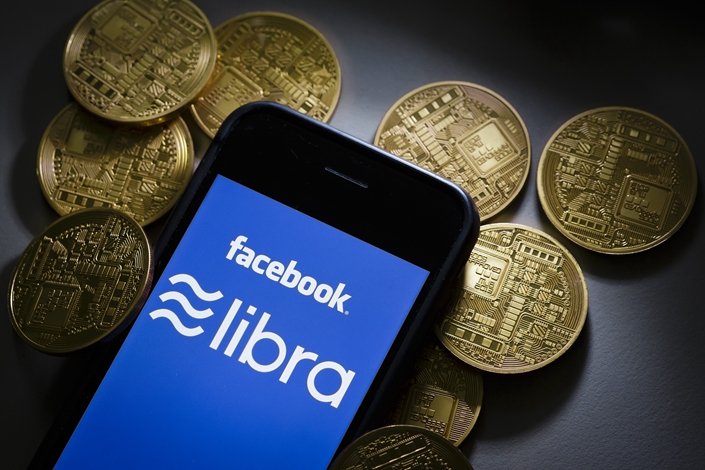 Smartphone screen that says "Facebook Libra" with tokens in background