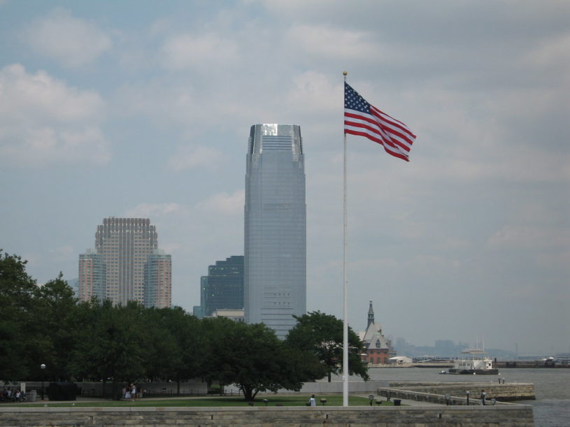 Tall skyscraper in New York City, Goldman Sachs headquarters, with American Flag in foreground