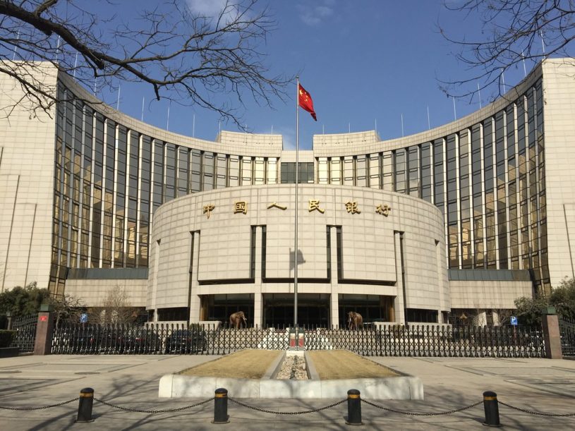 Outside view of People's Bank of China headquarters with Chinese flag flowing in the wind
