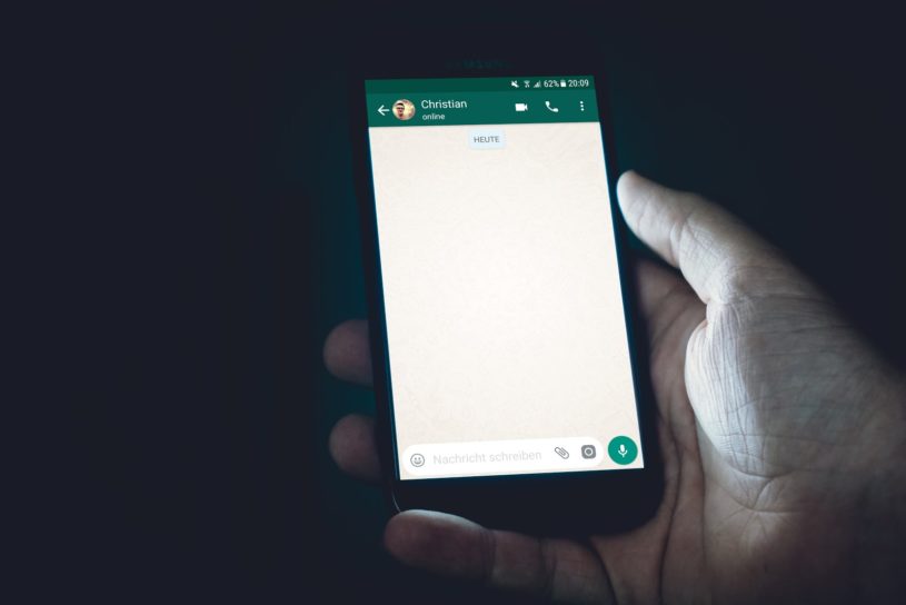 Person holding smartphone and making financial banking transaction with messenger app WhatsApp