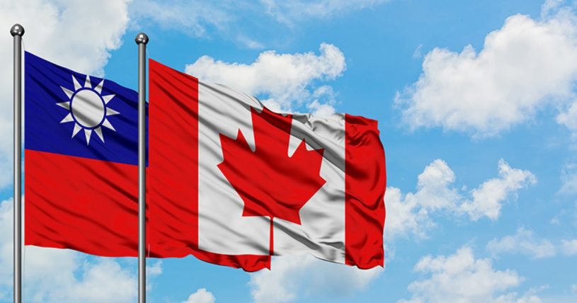 Taiwanese and Canadian flags waiving in the wind with blue sky and clouds in background.
