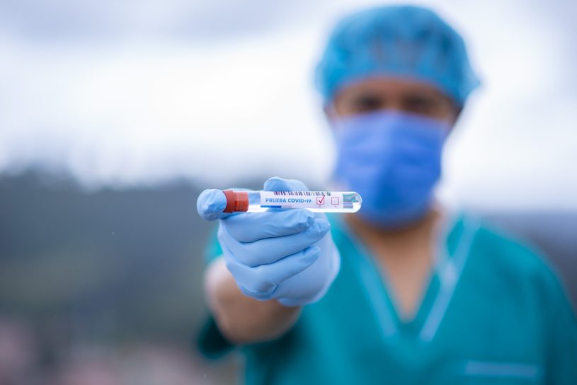 Medical doctor holding vile of COVID-19 infused blood for the topic of insurance