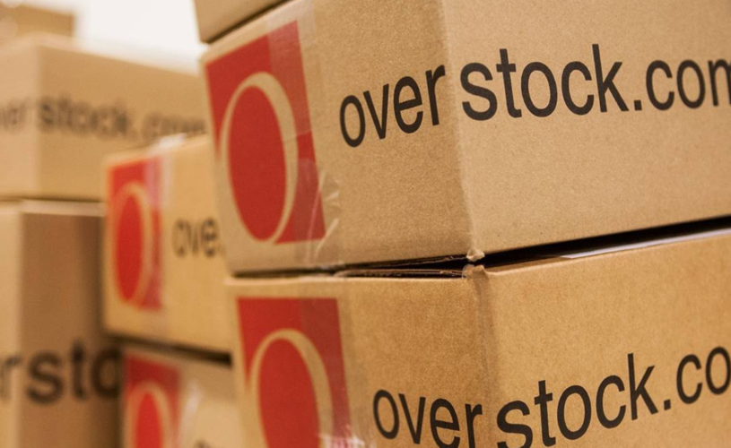 Brown cardboard boxes stock on top of each other that say "Overstock.com"