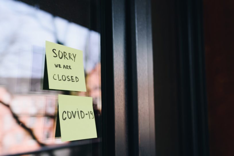 Business shut down due to COVID-19 with person wondering which stocks to buy in economic recession.