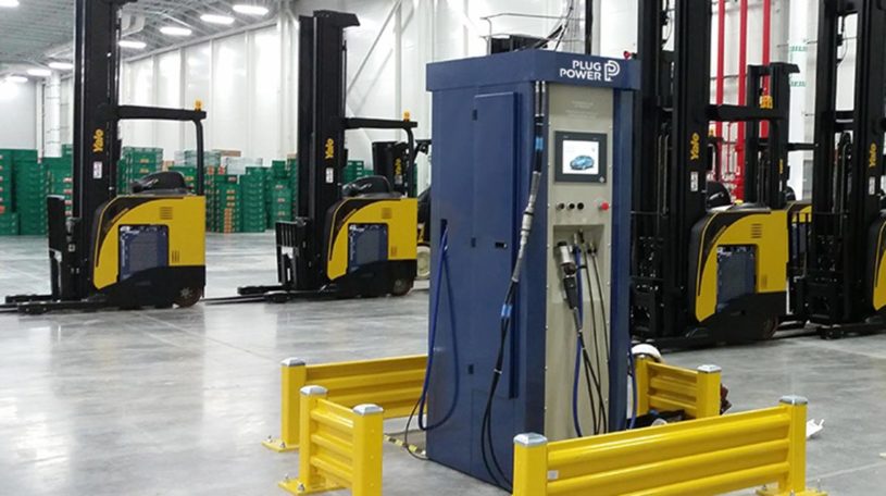 Blue and gray petroleum pump in warehouse with forklifts in background