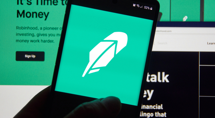 Stock trader holding an iPhone which has the Robinhood stock trading app open