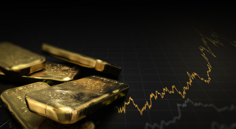 Gold bars with a financial chart behind them