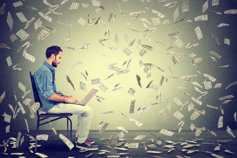 Man sitting in a chair and using his laptop to find the best stocks to buy and hold forever.