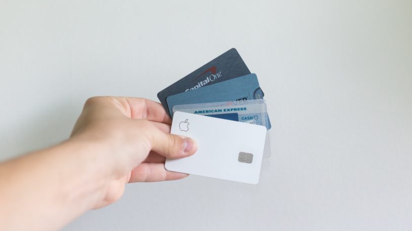Millennial male holding four credit cards and trying to get out of debt.