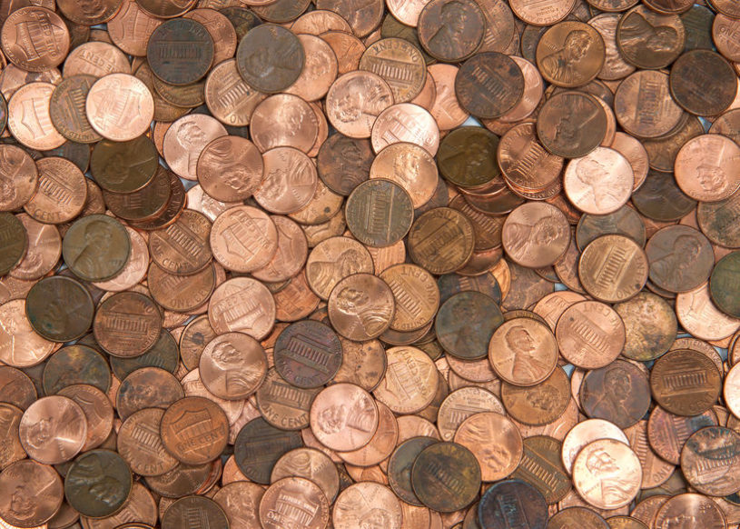 Lots of US pennies laid out on a table.