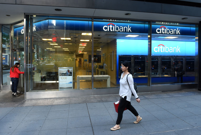 Woman walking in front of a Citibank in New York City