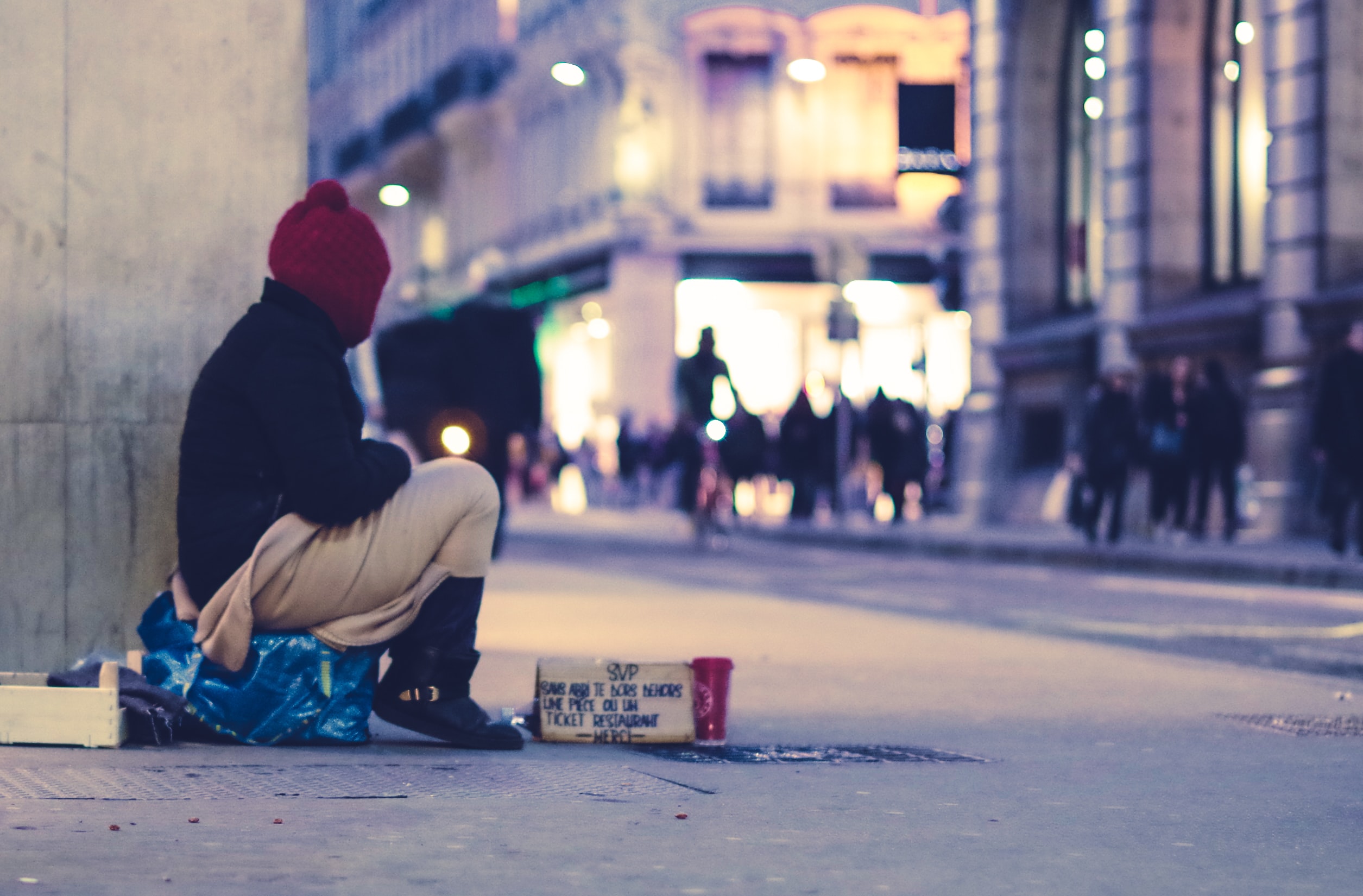 Homeless person sitting on the street.