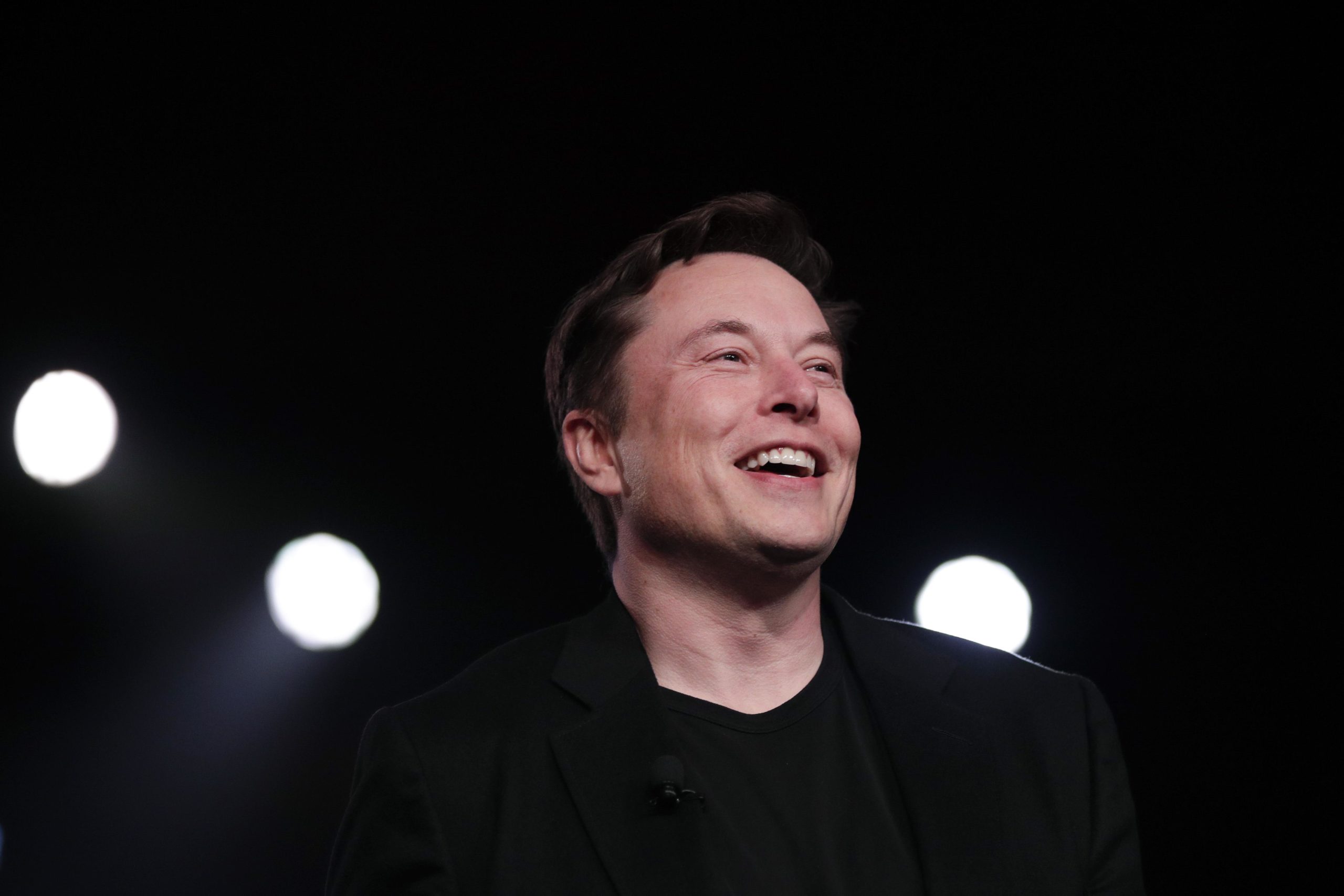 Elon Musk against a dark background