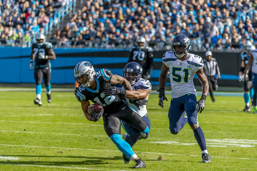 NFL player running and getting tackled by a defensive player.