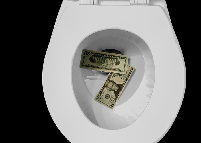 US dollar notes down the toilet bowl.