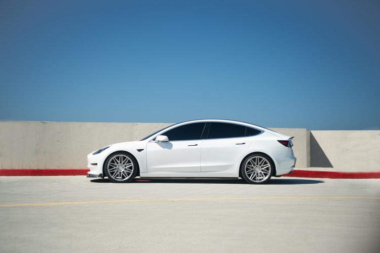 Tesla's electric white car against a clear-blue sky.