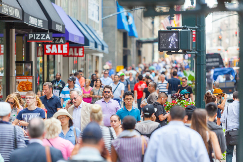 Busy Americans walking along a busy street in New York City, not paying attention to the price of Bitcoin.