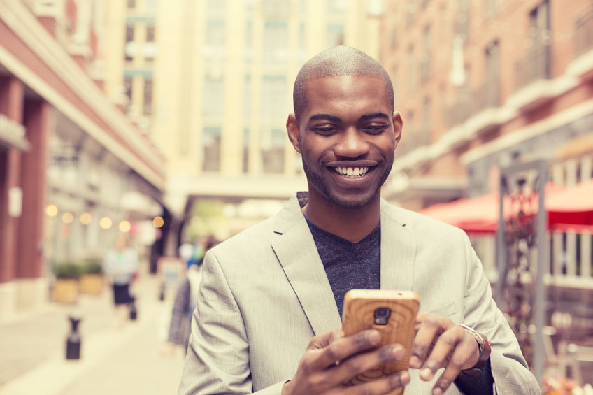 Young black man standing in the street and trading the top stocks on Robinhood