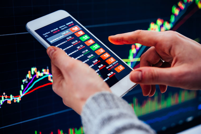 A trader or a financial analyst checking the recent stock exchange trends using the smartphone.