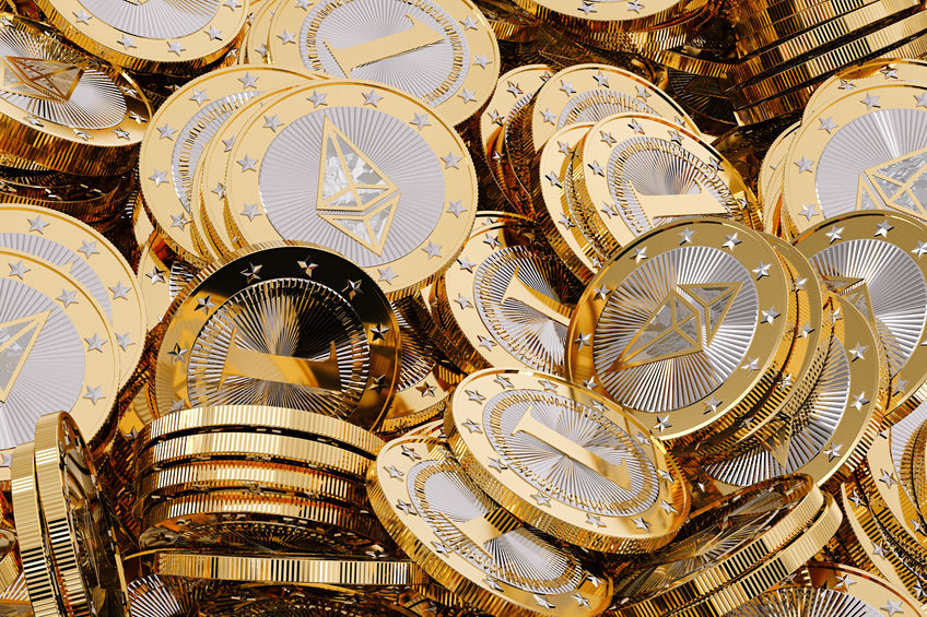 Several shiny ethereum tokens (gold and silver) stacked on top of each other