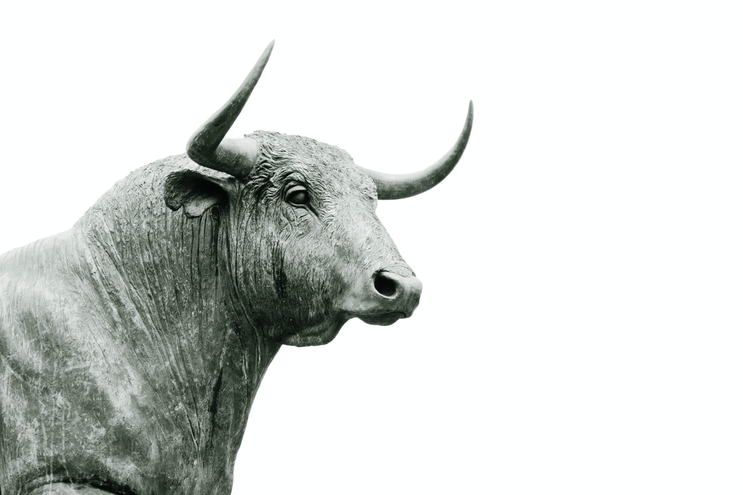 Statue of a grey bull, signaling Bitcoin's bullish price, with a white background.