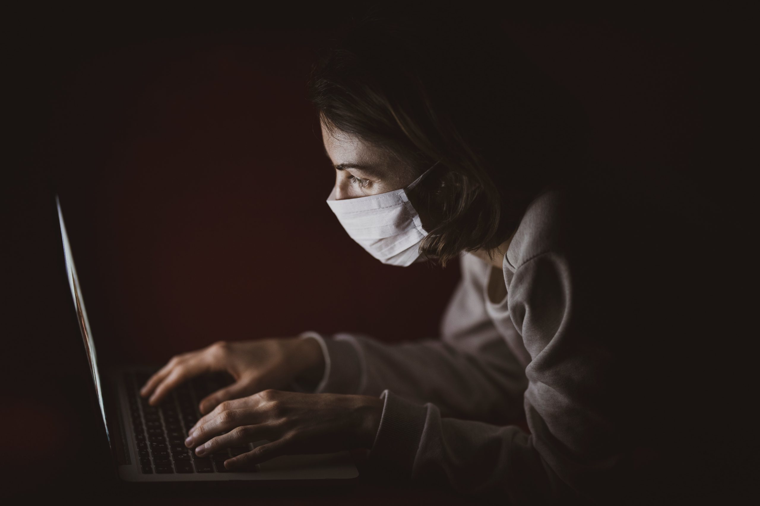 Young woman wearing a medical mask and searching Google to see if the term "bitcoin" is more popular than the term "covid-19".