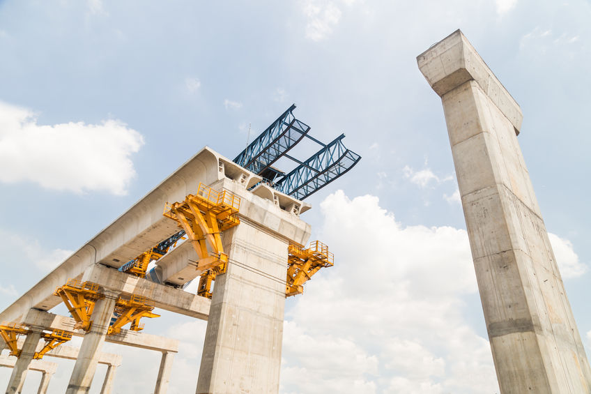Bridge in construction with blue sky and clouds in background.