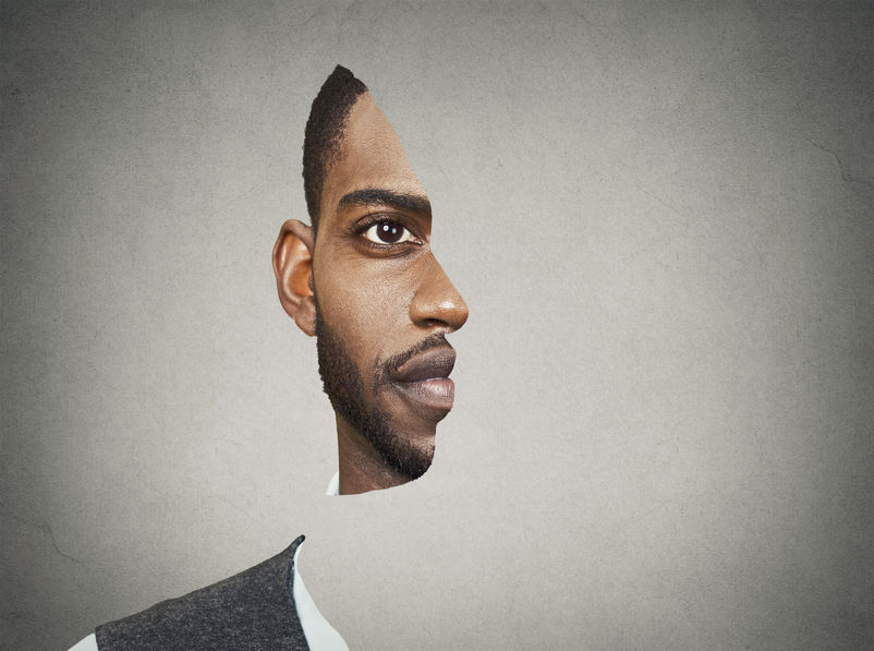 Optical illusion surrealistic portrait front with cut out profile of a young man isolated on grey wall background