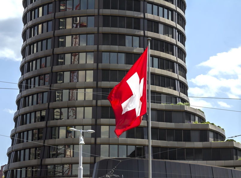 BIS building in Basel with a Swiss flag in front