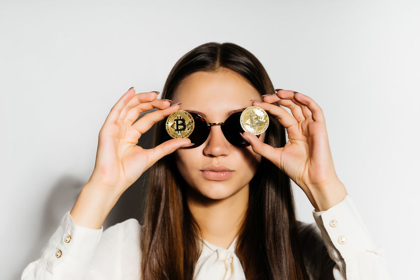 Young woman holding two bitcoins