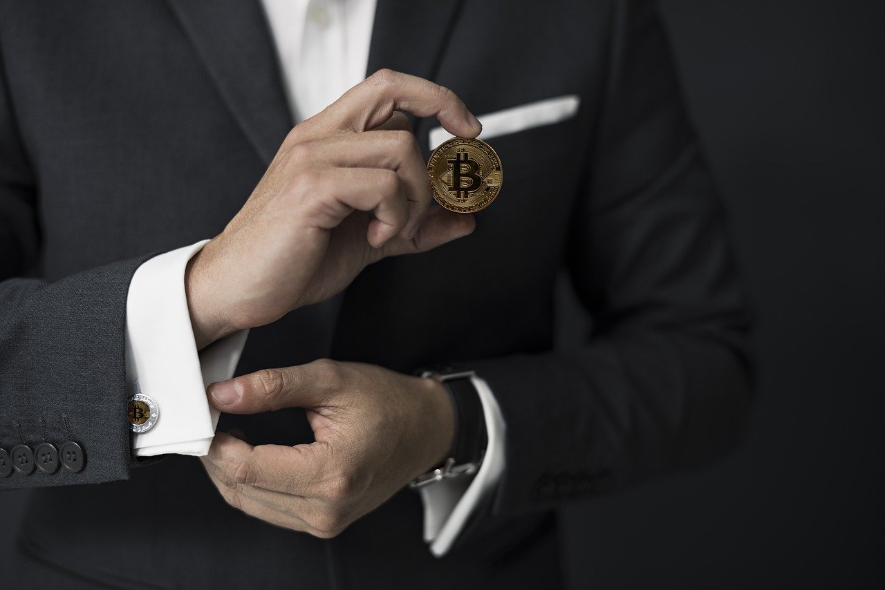 Business man wearing suit and holding Bitcoin.