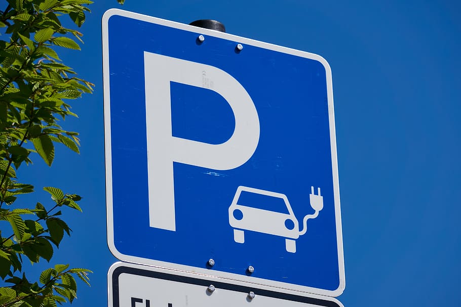 Blue car parking sign with a symbol of an electric vehicle charging.