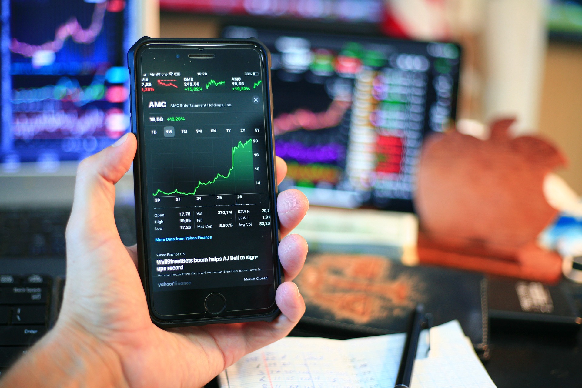 A man holding a smartphone to look at AMC stock performance.