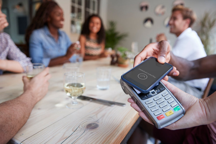Close Up Of Customer In Restaurant Paying Bill With Contactless Phone App