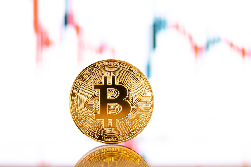 Gold Bitcoin crypto currency on background of chart diagram.