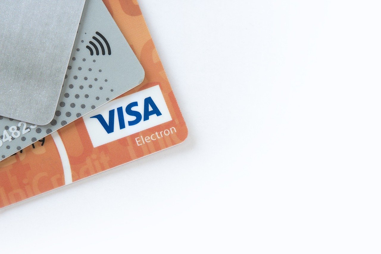 Visa credit cards laid out on a white desk.
