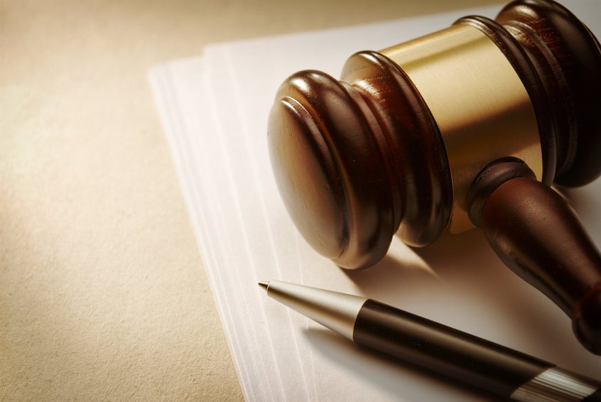Image of a gavel on some paper next to a pen