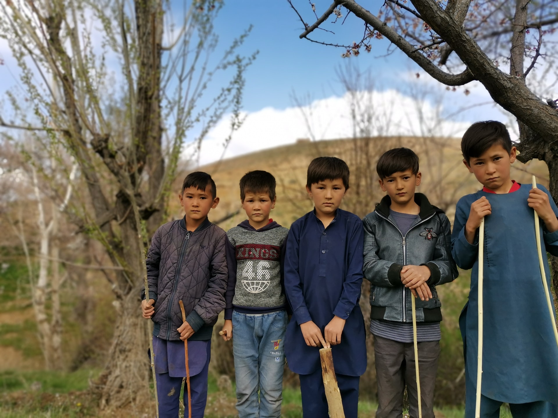 Young children running on a dirt road in Afghanistan.