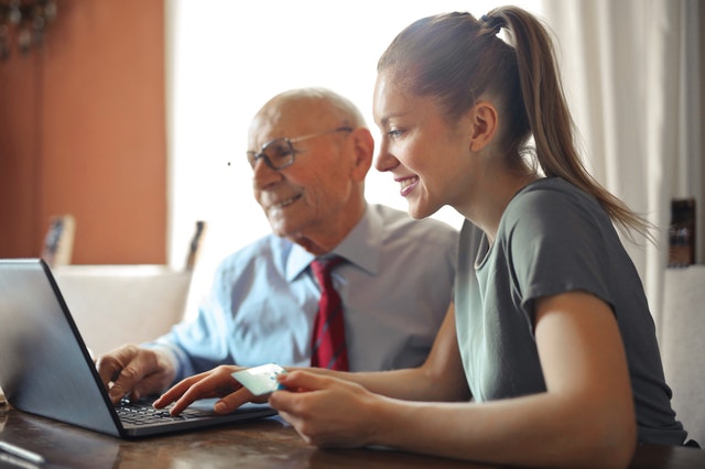 Image of older man and younger woman making an online payment