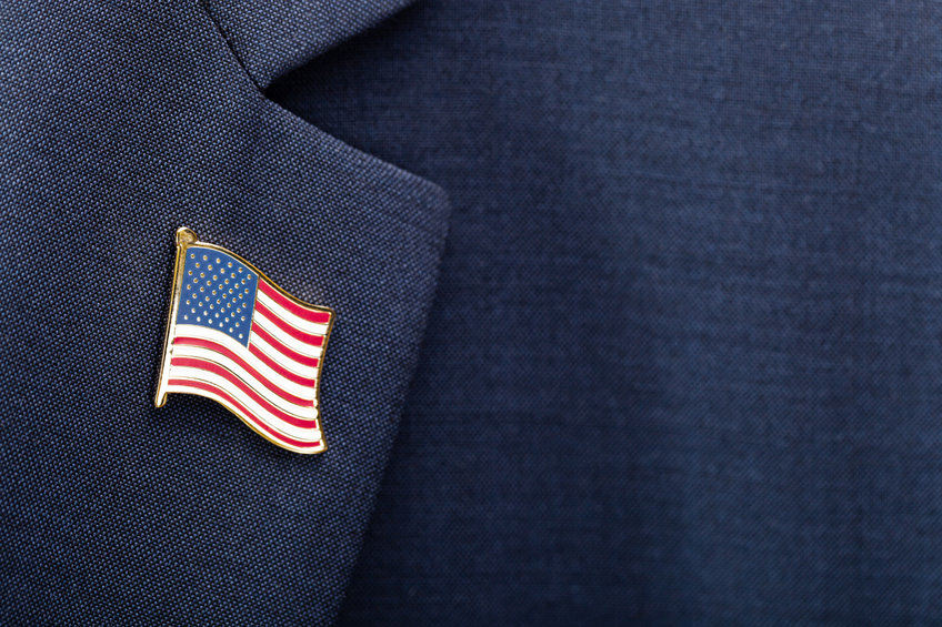 Image of a US flag pin on a person in a suit