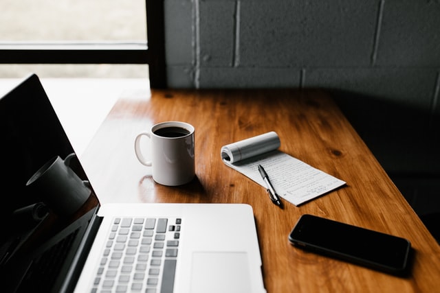 Image of computer on a desk with a cup of coffee