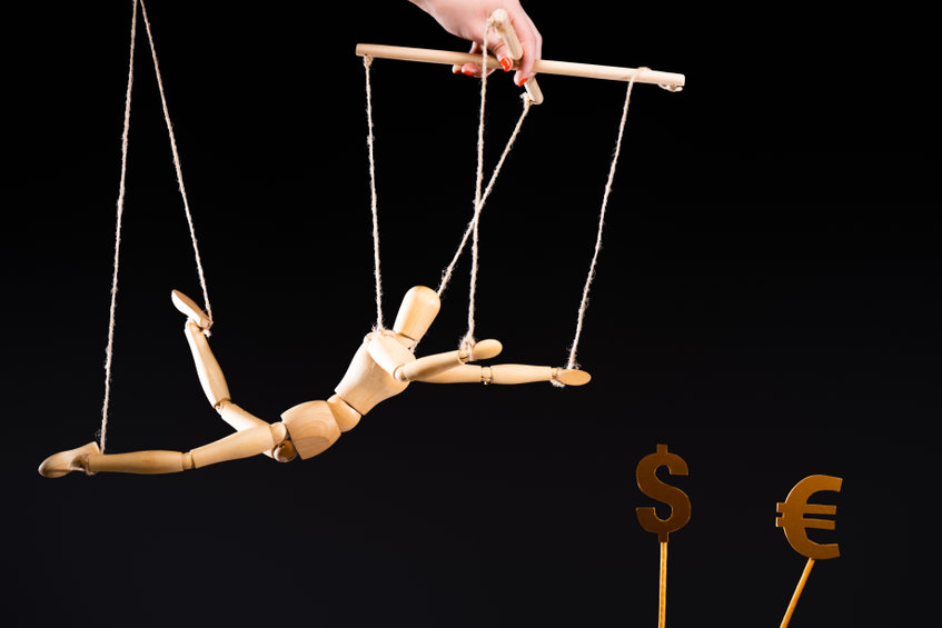 Image of a puppet being guided towards dollar and euro symbols