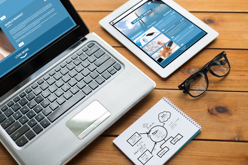 Image of laptop tablet and a pair of glasses with UX design wireframe