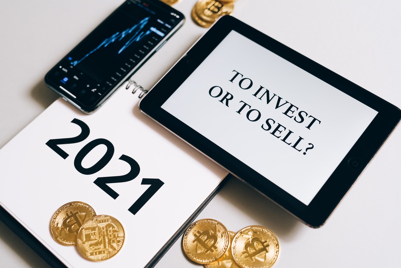 An image of bitcoin coins, a smart phone, and a tablet.