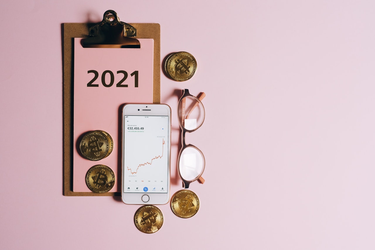 A notebook, iphone with several BTC coins.