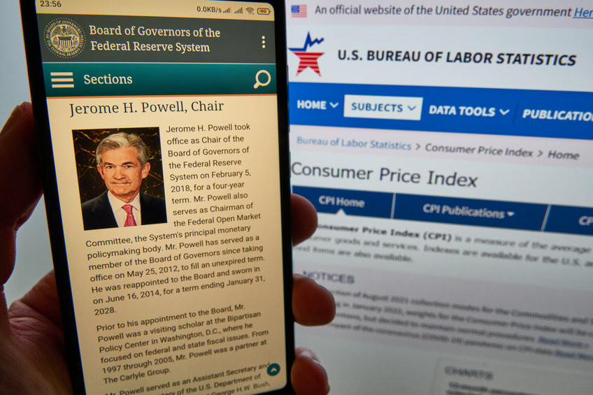 A smartphone screen shows details of Jerome H. Powell page on FRB web site, CPI Home page of US Bureau of Labor Statistics on the background.