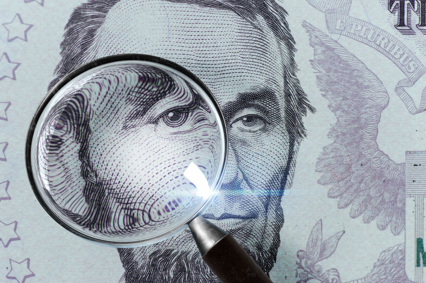 US President Abraham Lincoln face on the five dollar bill macro, 5 USD, US money close up under magnifying glass